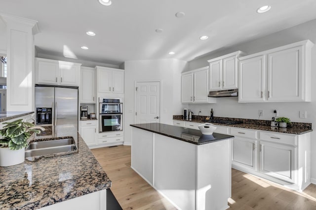 kitchen featuring white cabinetry, a kitchen island, light wood-type flooring, and appliances with stainless steel finishes