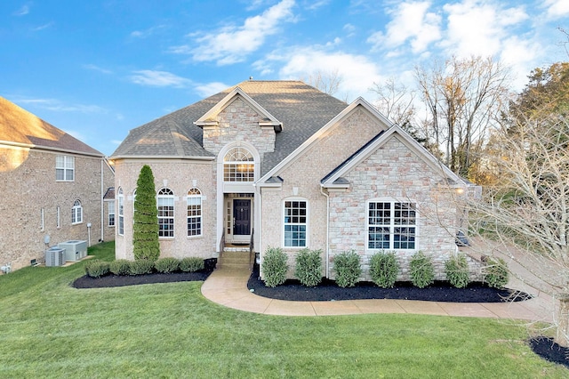 view of front facade with a front yard and central AC