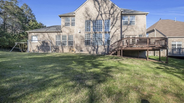 back of property featuring a lawn and a wooden deck