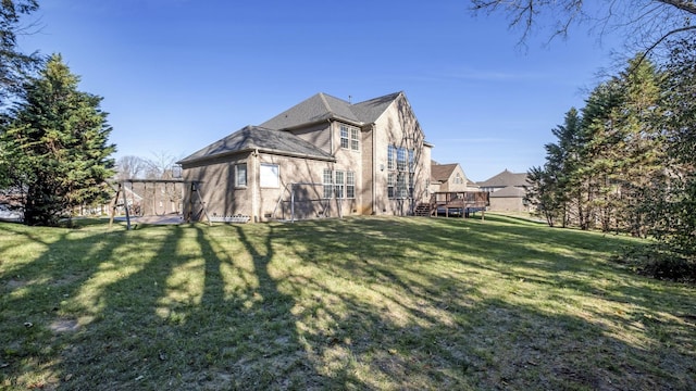 back of property with a lawn and a deck