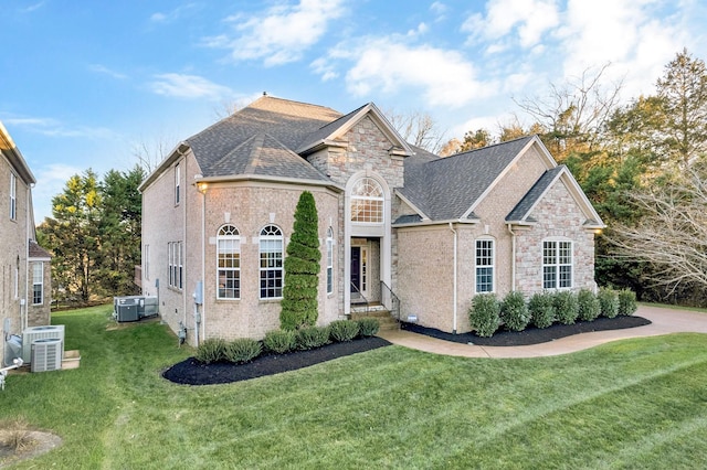 view of front of property with a front yard and central AC