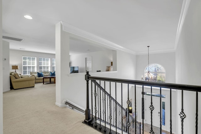 hallway featuring carpet flooring, crown molding, and a notable chandelier