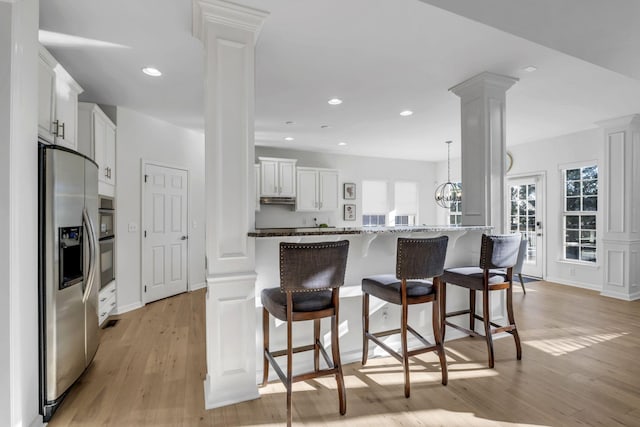 kitchen with white cabinets, plenty of natural light, stainless steel fridge, and light hardwood / wood-style flooring