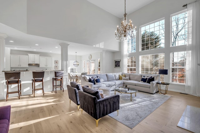 living room featuring plenty of natural light, light hardwood / wood-style floors, and a high ceiling