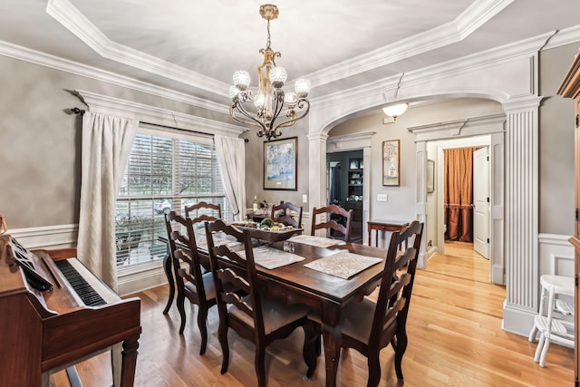 dining space featuring a raised ceiling, light hardwood / wood-style flooring, and crown molding