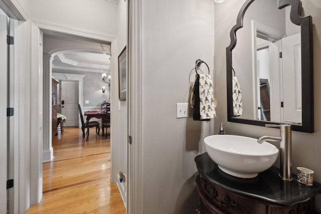 bathroom with wood-type flooring, vanity, and ornamental molding