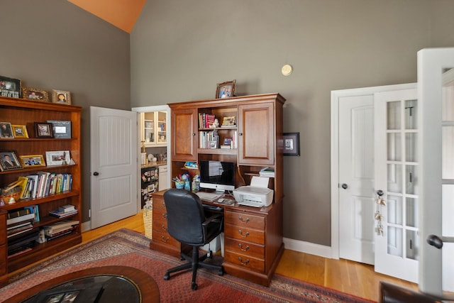 home office featuring light hardwood / wood-style floors and high vaulted ceiling