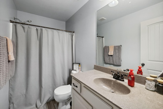 bathroom with walk in shower, hardwood / wood-style flooring, vanity, and toilet