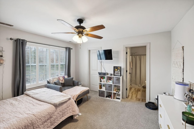 carpeted bedroom featuring ensuite bath and ceiling fan