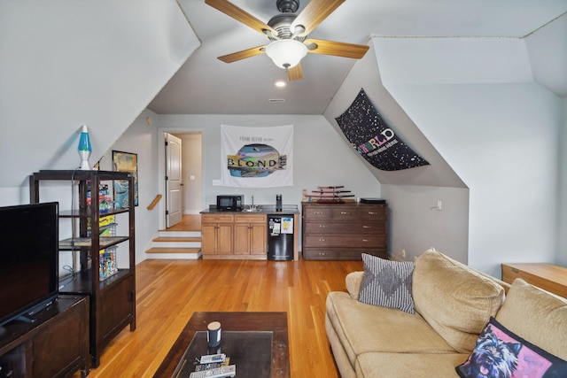 living room featuring light hardwood / wood-style floors, ceiling fan, and lofted ceiling