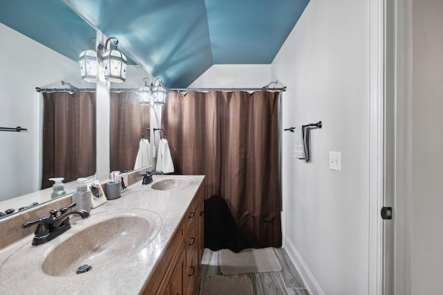 bathroom with hardwood / wood-style flooring, vanity, shower / bath combo, and vaulted ceiling