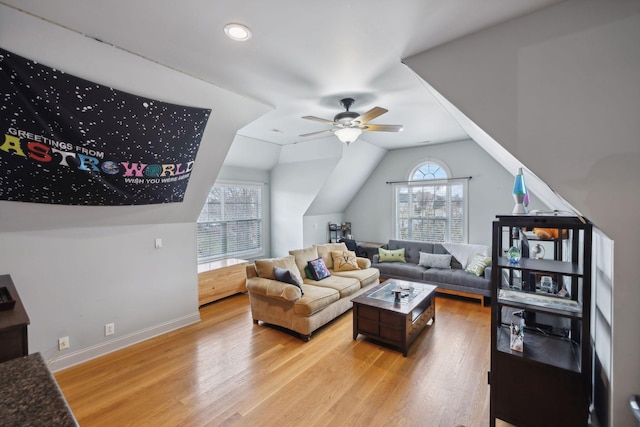 living room featuring ceiling fan, light hardwood / wood-style flooring, and vaulted ceiling