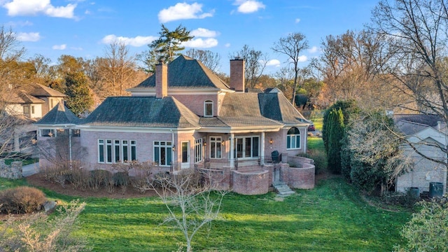 rear view of property with a lawn and a patio area