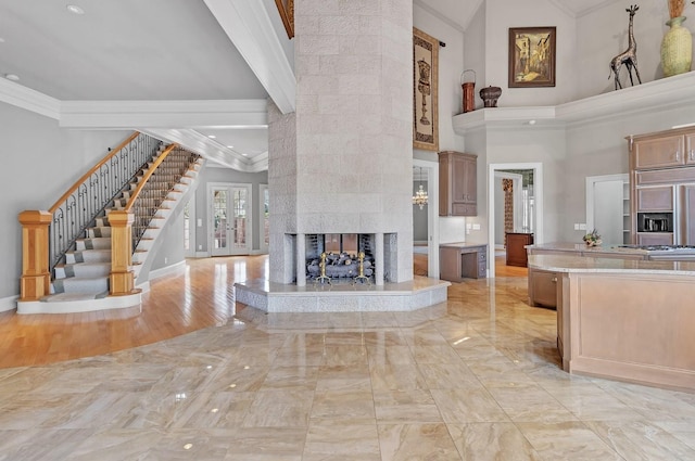 kitchen with high vaulted ceiling, a multi sided fireplace, crown molding, paneled fridge, and light hardwood / wood-style floors