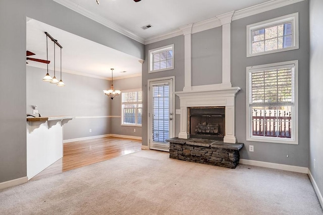 living room with an inviting chandelier, a stone fireplace, crown molding, a towering ceiling, and light hardwood / wood-style floors