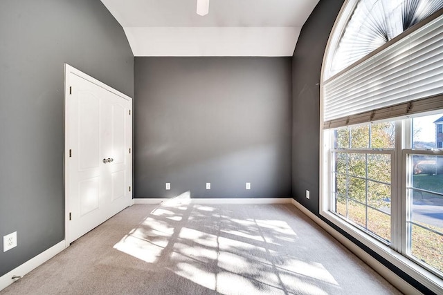 unfurnished room with light carpet and vaulted ceiling