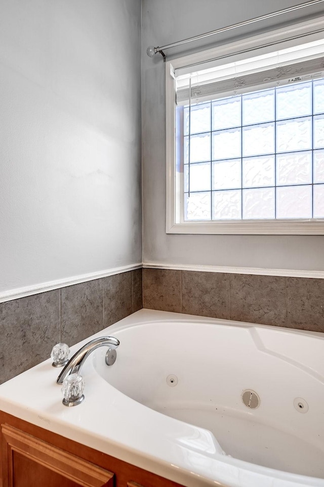 bathroom featuring plenty of natural light and a tub to relax in