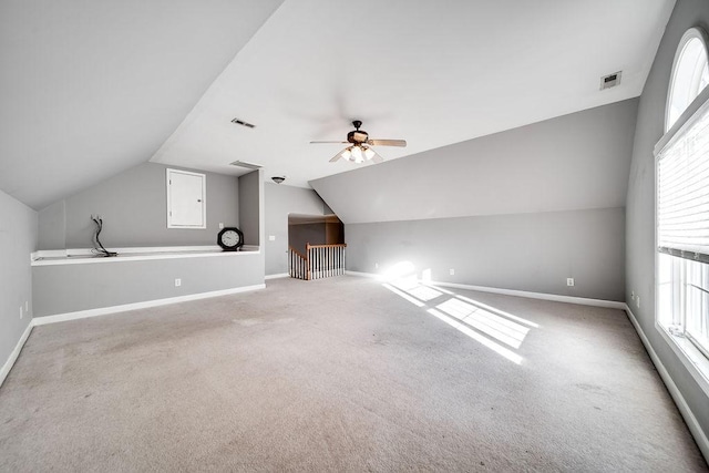 additional living space featuring carpet, plenty of natural light, and vaulted ceiling