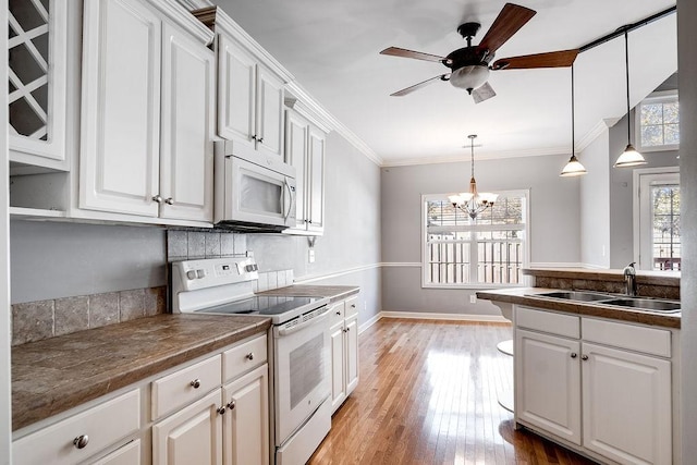 kitchen featuring sink, white cabinets, light hardwood / wood-style floors, and white appliances