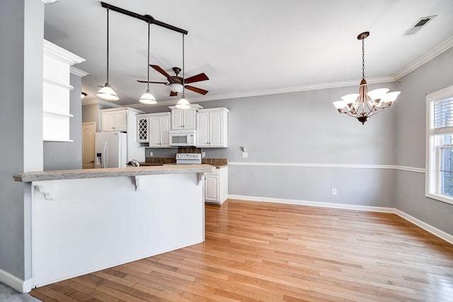 kitchen with white cabinetry, light hardwood / wood-style flooring, kitchen peninsula, white appliances, and a breakfast bar area