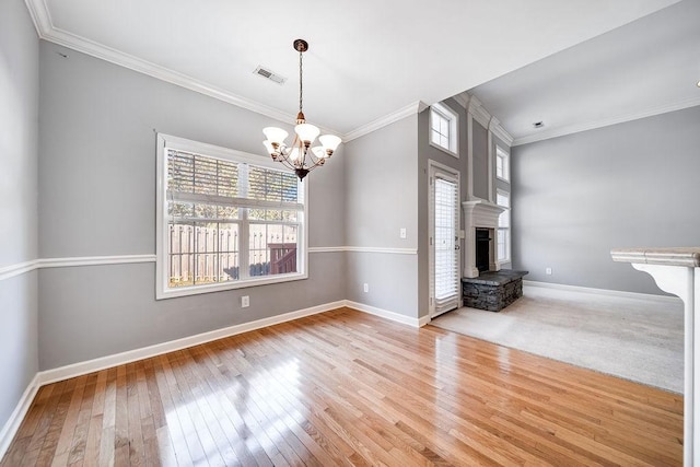 unfurnished living room with a chandelier, light hardwood / wood-style flooring, and ornamental molding