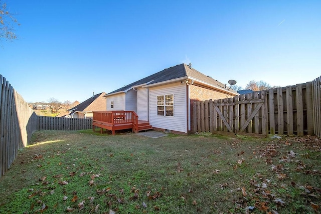 rear view of property featuring a deck and a yard