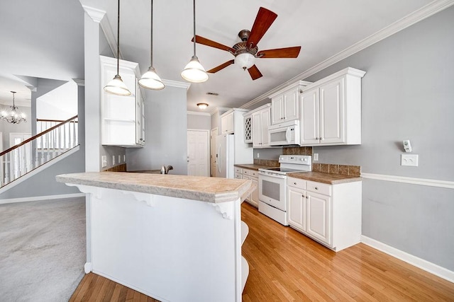 kitchen featuring a breakfast bar, white appliances, white cabinets, light hardwood / wood-style floors, and kitchen peninsula