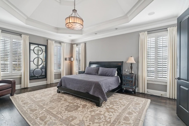 bedroom with dark wood-type flooring, multiple windows, and a raised ceiling