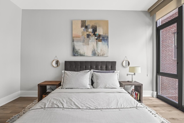 bedroom with light wood-type flooring and multiple windows