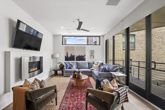 living room with wood-type flooring and ceiling fan