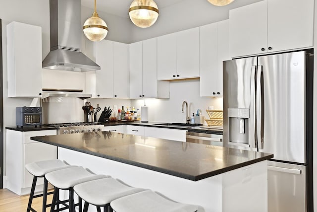 kitchen featuring wall chimney exhaust hood, stainless steel appliances, sink, white cabinets, and light hardwood / wood-style floors