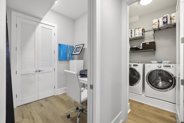 clothes washing area featuring separate washer and dryer and light hardwood / wood-style flooring