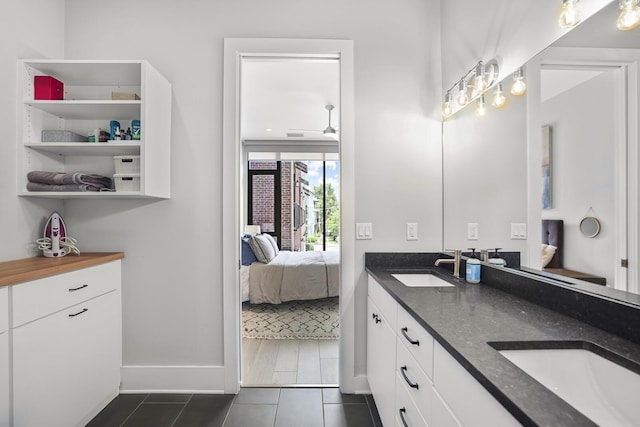 bathroom with tile patterned flooring, vanity, and ceiling fan