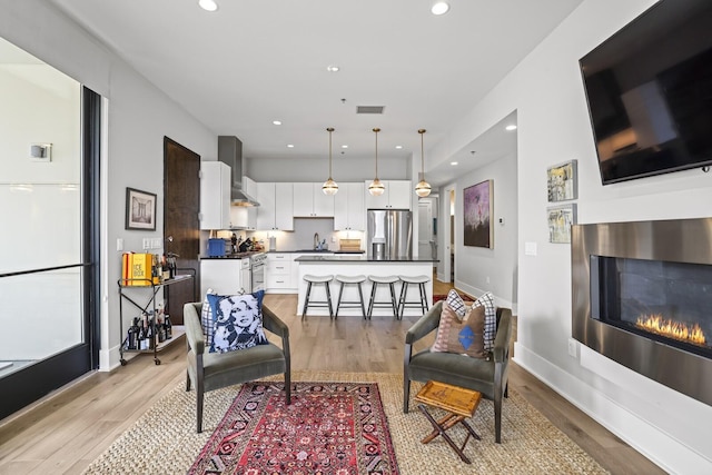 living room featuring light wood-type flooring and sink