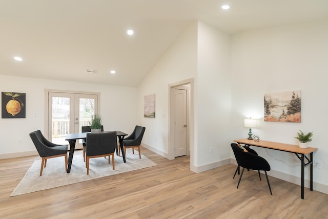 dining area with french doors, high vaulted ceiling, and light hardwood / wood-style flooring