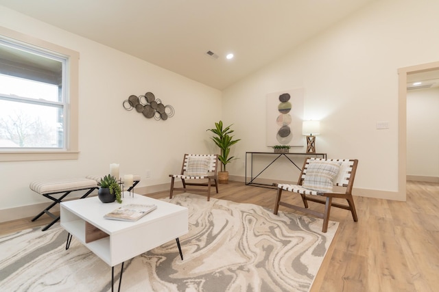 sitting room featuring light wood-type flooring and vaulted ceiling