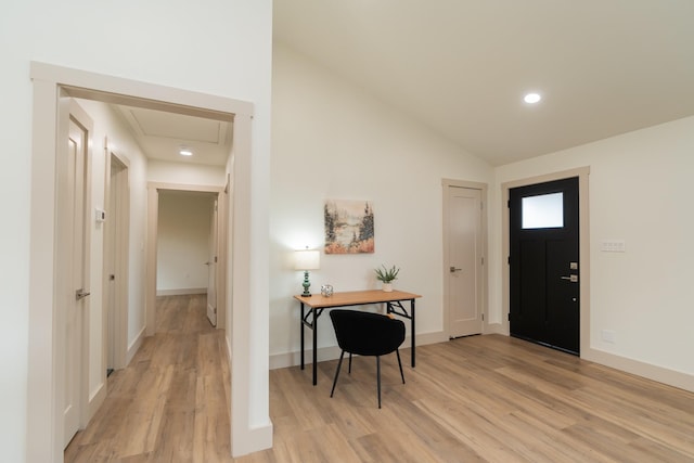 foyer with lofted ceiling and light wood-type flooring