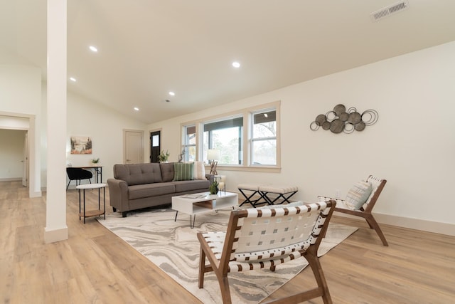 living room featuring light wood-type flooring and high vaulted ceiling