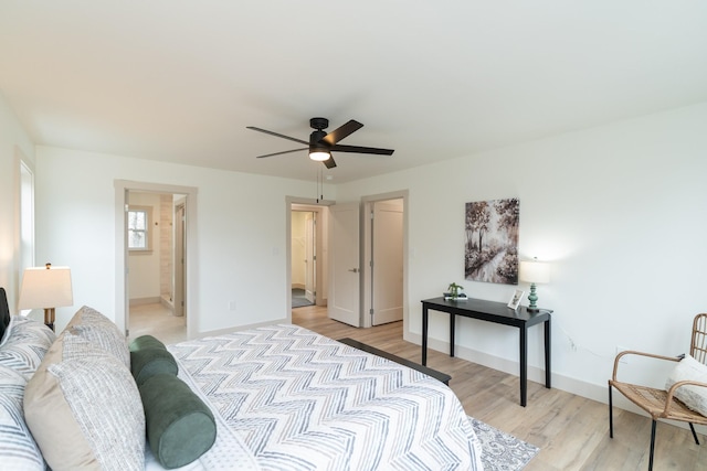 bedroom with ensuite bathroom, light hardwood / wood-style flooring, and ceiling fan