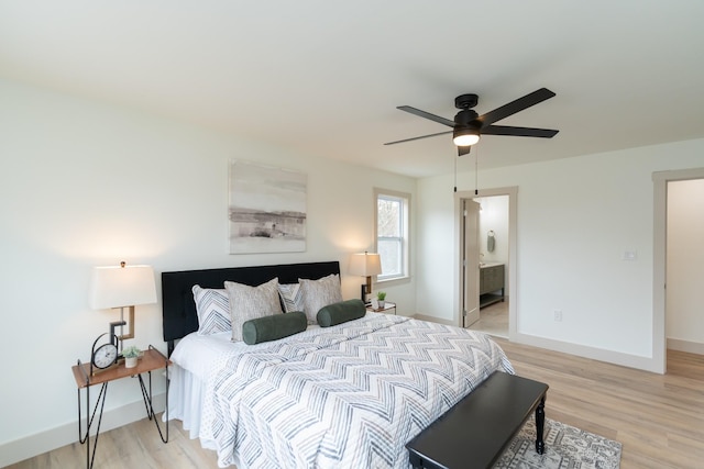 bedroom with ceiling fan, light hardwood / wood-style floors, and ensuite bath