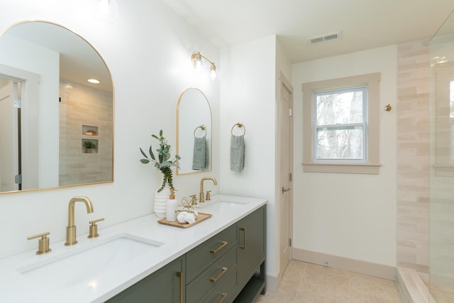 bathroom featuring tile patterned floors, vanity, and a tile shower