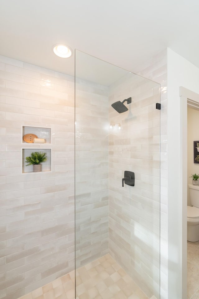 bathroom with toilet and tiled shower