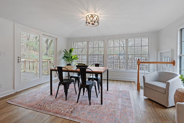 dining area featuring wood-type flooring and a notable chandelier