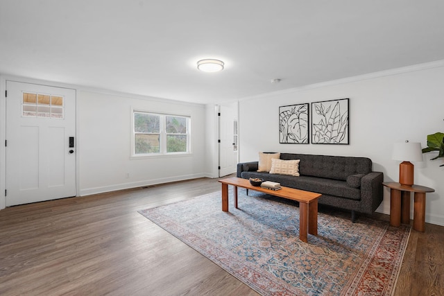 living room with ornamental molding and dark wood-type flooring