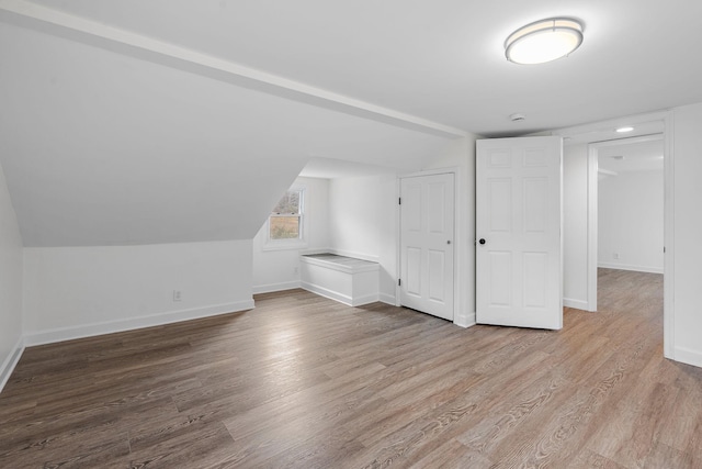 additional living space with wood-type flooring and lofted ceiling