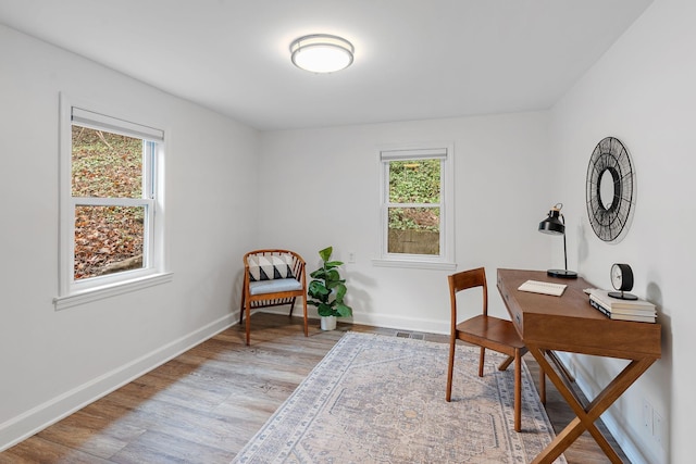 office with a healthy amount of sunlight and light hardwood / wood-style floors