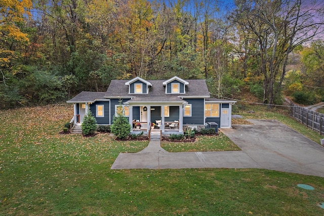 cape cod house with covered porch and a front lawn