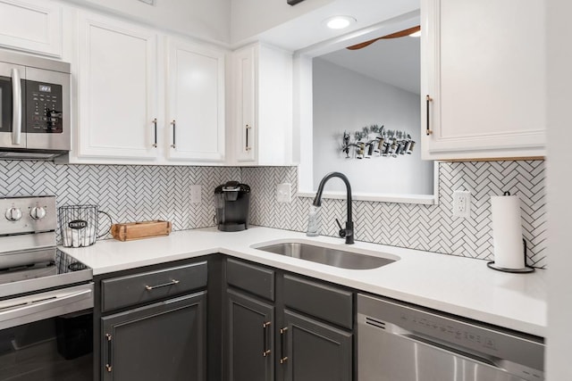 kitchen with sink, white cabinetry, stainless steel appliances, and tasteful backsplash