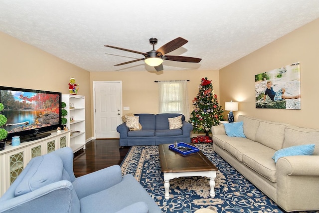 living room featuring ceiling fan, a textured ceiling, and hardwood / wood-style flooring