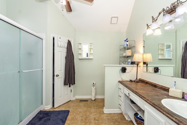 bathroom with tile patterned floors, vanity, vaulted ceiling, and a shower with shower door